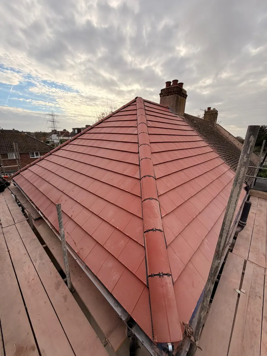New red tile hip roof with chimneys behind, FR Roofing Solutions